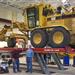 Road grader on lift in shop